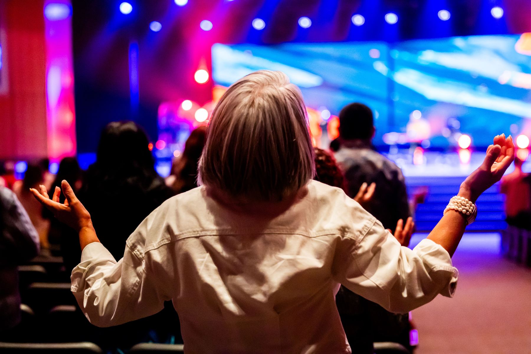 A member of the congregation raising their hands in worship