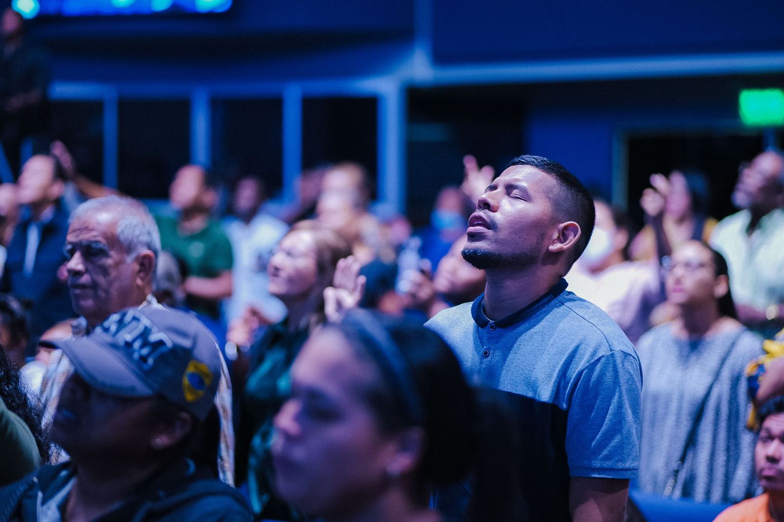 A young adult worshiping among a crowd at a Thursday night gathering