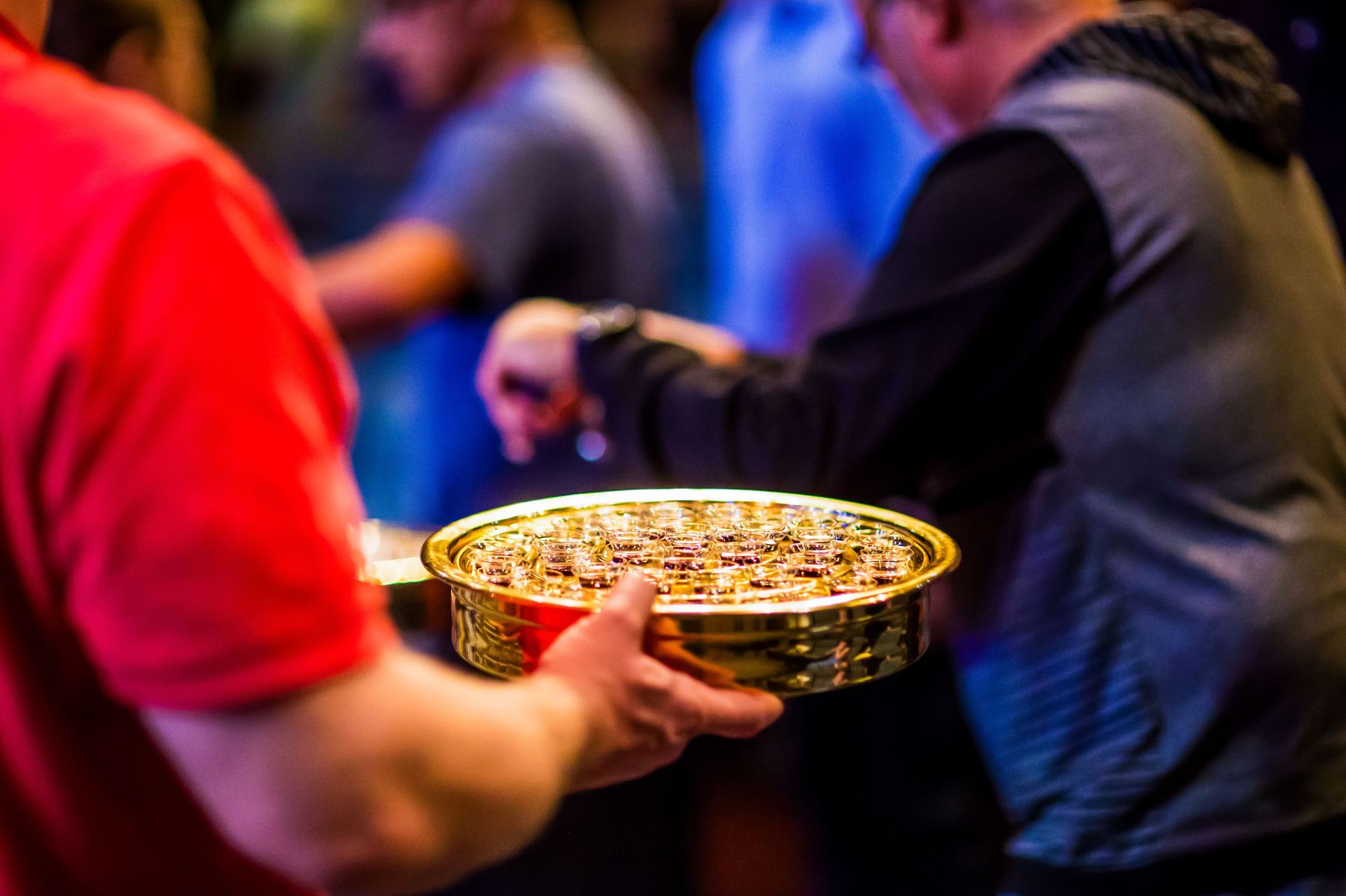 Volunteers passing a communion tray together during a Sunday gathering